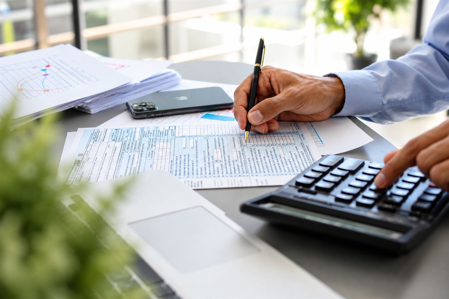 A person filling out a tax form at a desk.